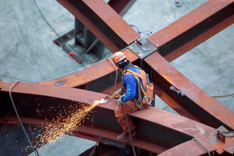 Photo of a construction worker welding on top of a steal beam taken by Los Angeles-based industrial photographer Ed Carreon. 