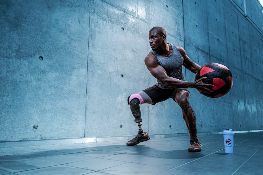 Portrait of althlete with prosthetic leg holding a ball, by Los Angeles fitness photographer Erik Isakson.