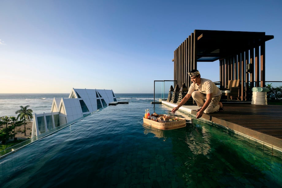 Portrait of server with floating tray on an infinity pool, by Singapore food photographer Felix Hug.