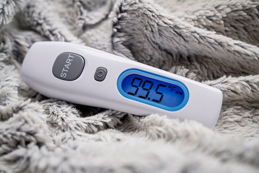 Inti St. Clair Home Med Essential shot of the touchless thermometer resting on a blanket
