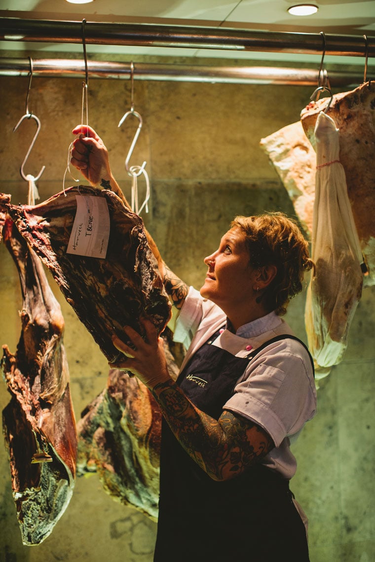 Photo by James Horan of a butcher hanging a slab of meat.