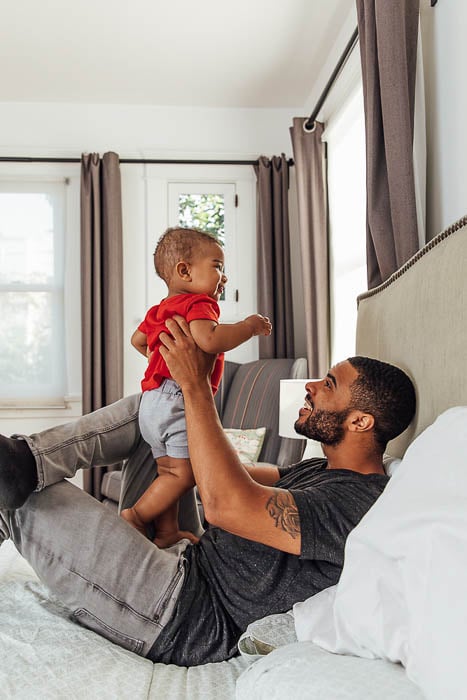 Photo of a father playing with his baby in bed taken by Los Angeles-based lifestyle photographer Jayme Burrows.