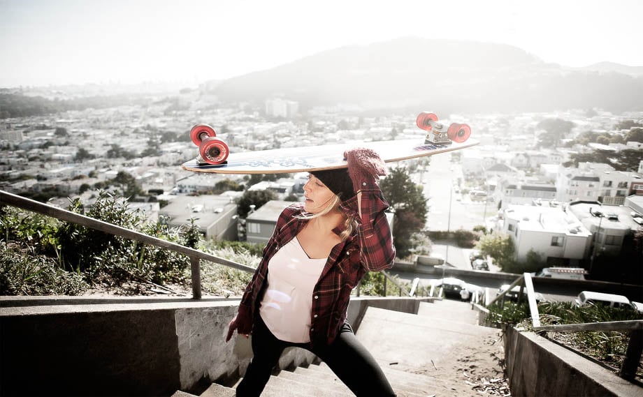 Photo of a woman holding a skate above her head taken by San Francisco-based lifestyle photographer Jayms Ramirez. 