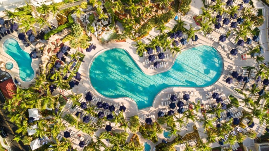 Aerial photo of Jeff Herron of a resort swimming pool surrounded by seats and umbrellas.