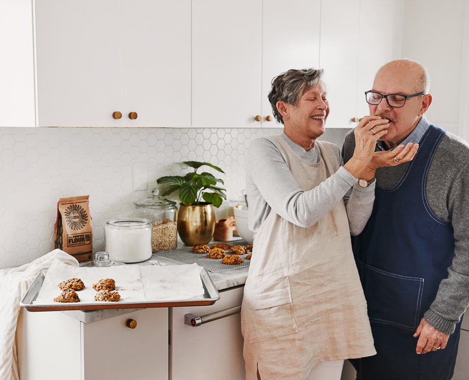 Photo of an elderly woman feeding her husband a baked cookie taken by Philadelphia-based food photographer Jillian Guyette. 