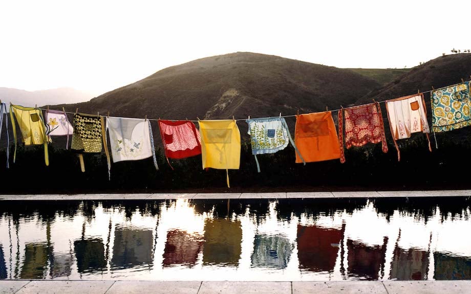 Photo of hanging colorful textiles over infinity pool with mountain backdrop, by Los Angeles product photographer Joe Schmelzer.