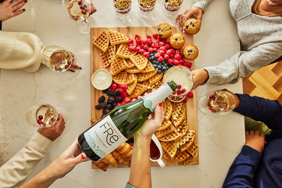 Photo of people drinking Fre Sparkling Brut and eating fruits and waffles taken by Boston-based food photographer Joe St. Pierre. 