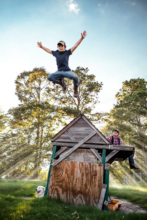 Photo of a young boy jumping off his small makeshift wooden home taken by Atlanta-based lifestyle photographer John Fulton. 