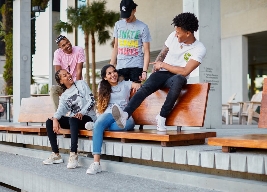 Photo of teenagers or young adults goofing around on a street bench taken by Miami-based lifestyle photographer John Olive. 