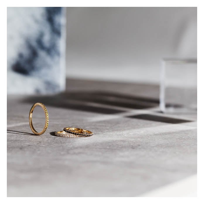 Photo of three gold rings resting on a grey stone surface taken by Berlin-based product photographer Jordana Schramm. 