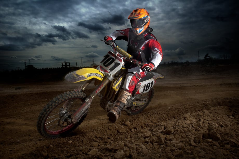 Photo by Justin Durner of a dirt biker driving by as the sky turns to dusk.