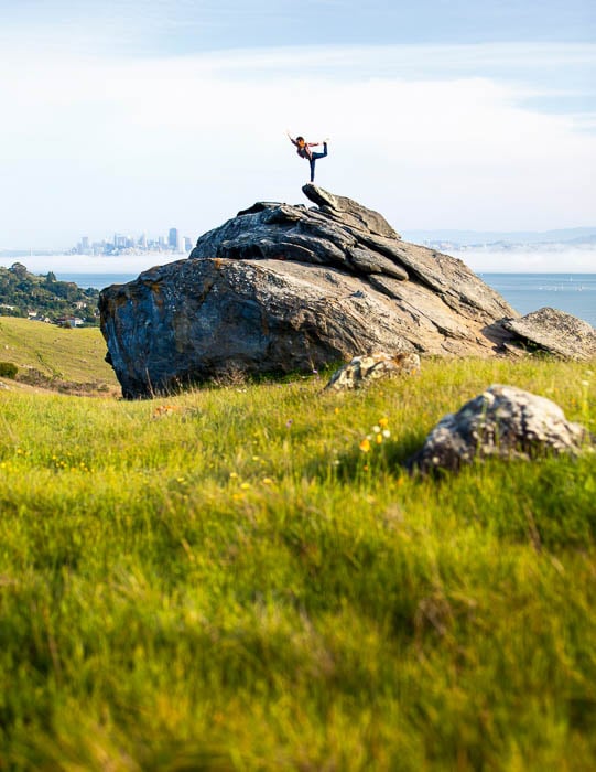 Photo of a woman in a yoga pose outside on top of a large rock taken by San Francisco-based sports and fitness photographer Kaare Iverson. 