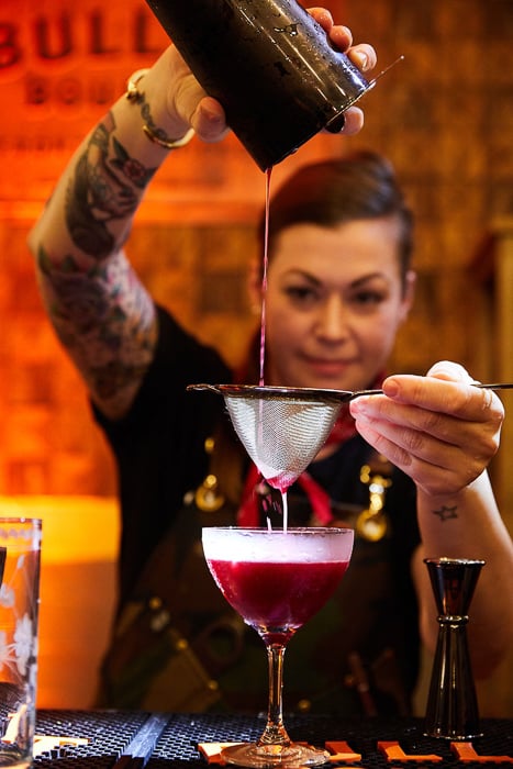 Photo of a female mixologist preparing a drink taken by New York photographer Lauren Volo. 