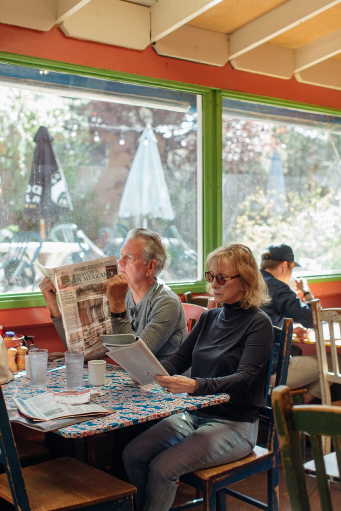 Photo of a couple reading newspapers at a table in diner for Life & Thyme.