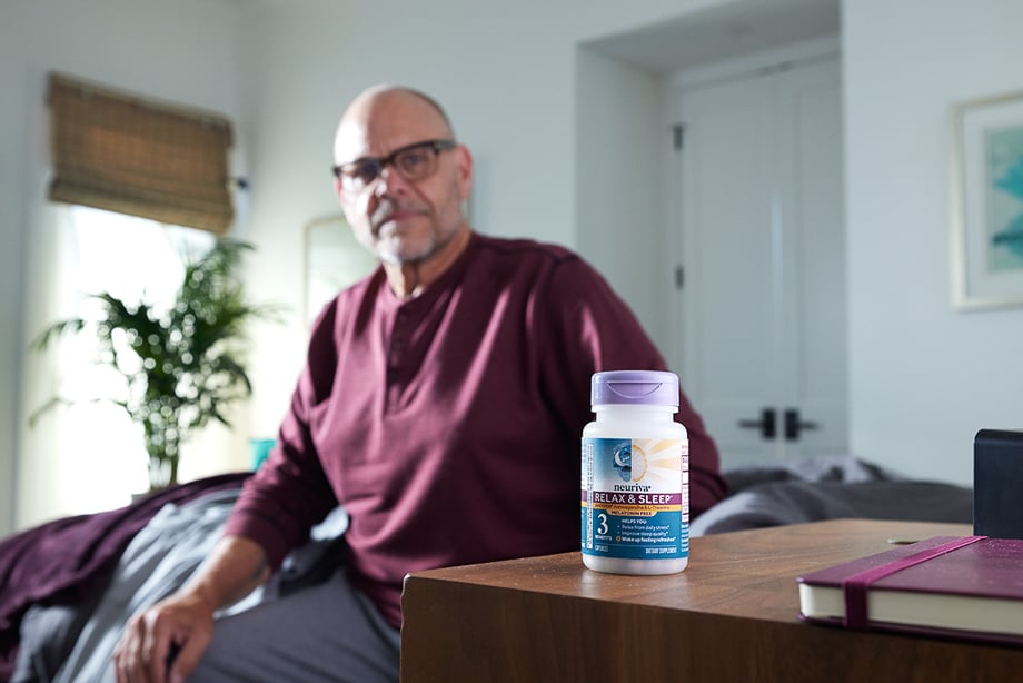 Photo of a Neuriva Relax and Sleep bottle on a bedside table with Alton Brown in the background taken by Lindsey Dowell. 