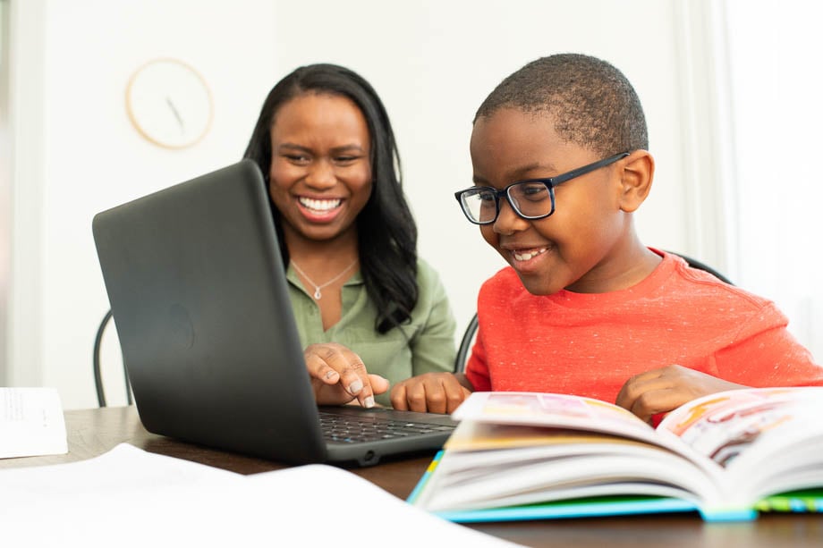Photo of an African-American mom helping her child with the homework on a laptop taken by Philadelphia-based lifestyle photographer Mark Tassoni. 
