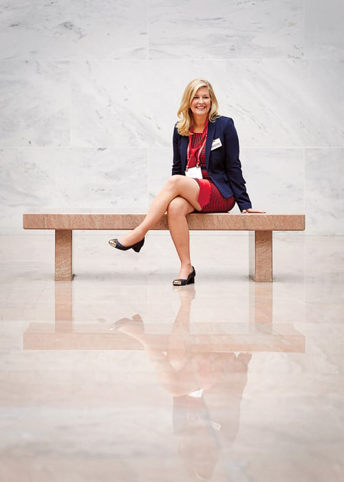 Photo of a woman seated on a bench, presumably at a conference, taken by Washington DC-based corporate photographer Matthew Rakola. 