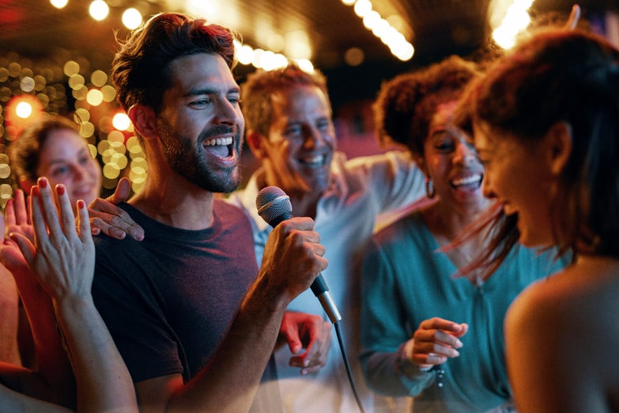 Photo of a man singing during Karaoke night with his friends taken by Miami-based lifestyle photographer Mauricio Candela. 