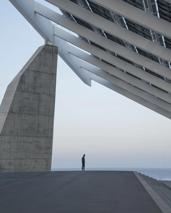 Photo of a man standing below a giant structure taken by Los Angeles-based architecture photographer Minh T of This Minty Moment. 