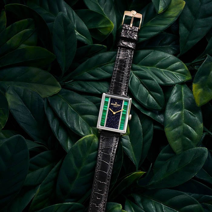 Photo of a black leather Gomelsky watch with green sides resting on green leaves taken by Philadelphia-based product photographer Nell Hoving. 