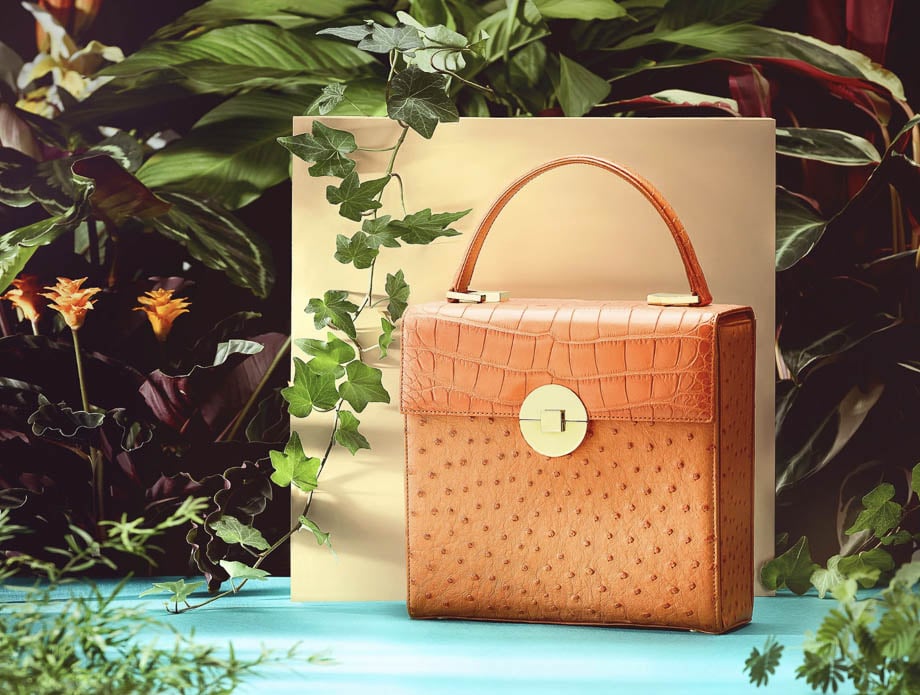 Photo of a light brown leather handbag surrounded by plants taken by Berlin-based product photographer Nils Wilbert. 
