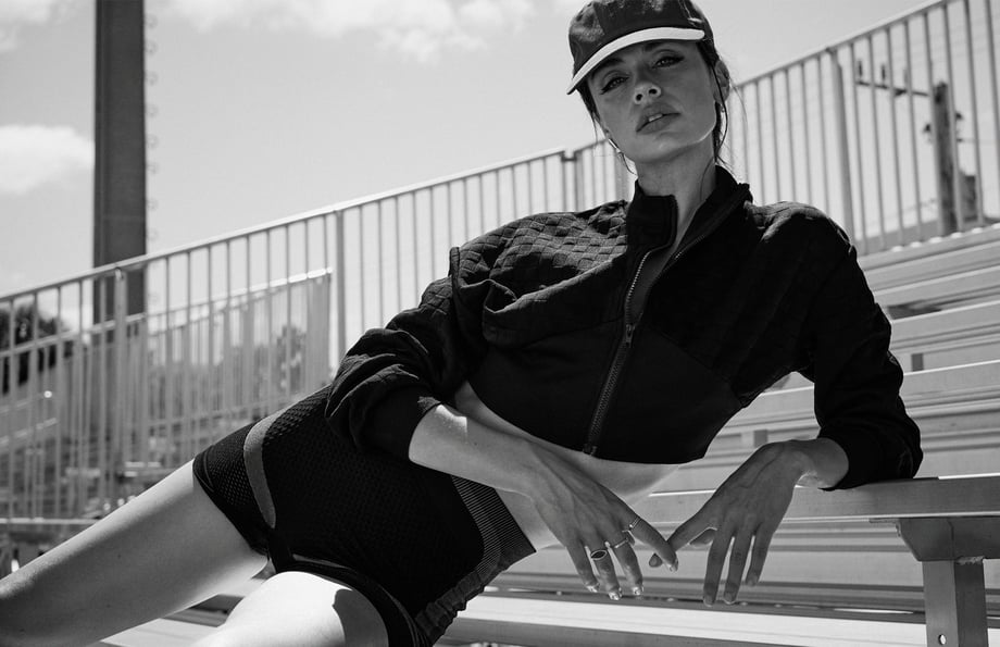Photo by Orlando Noa of a woman reclining on bleachers in athletic gear.
