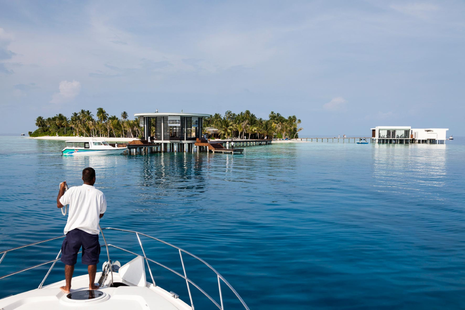 Photo of a staff member aboard a yacht overlooking rooms at the Jumeirah Dhevanafushi taken by Singapore-based hospitality photographer Owen Raggett. 