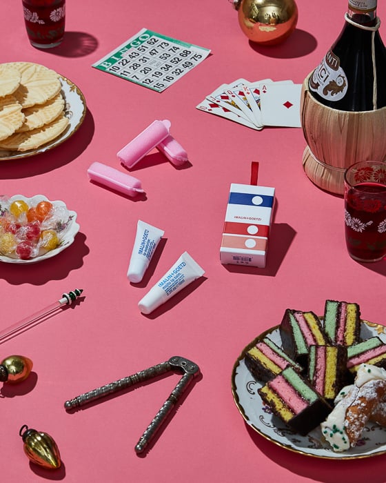 Photo of Malin+Goetz lip balm resting on a table with food and drink around it taken by New York-based product photographer Paul Crispin Quitoriano. 