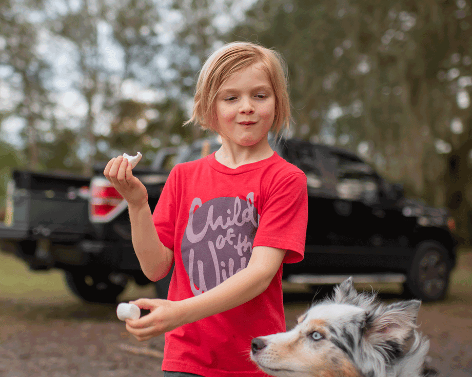 Gif by Richmond Gibbs of a child pulling a marshmallow away from his dog, who is trying to eat it.