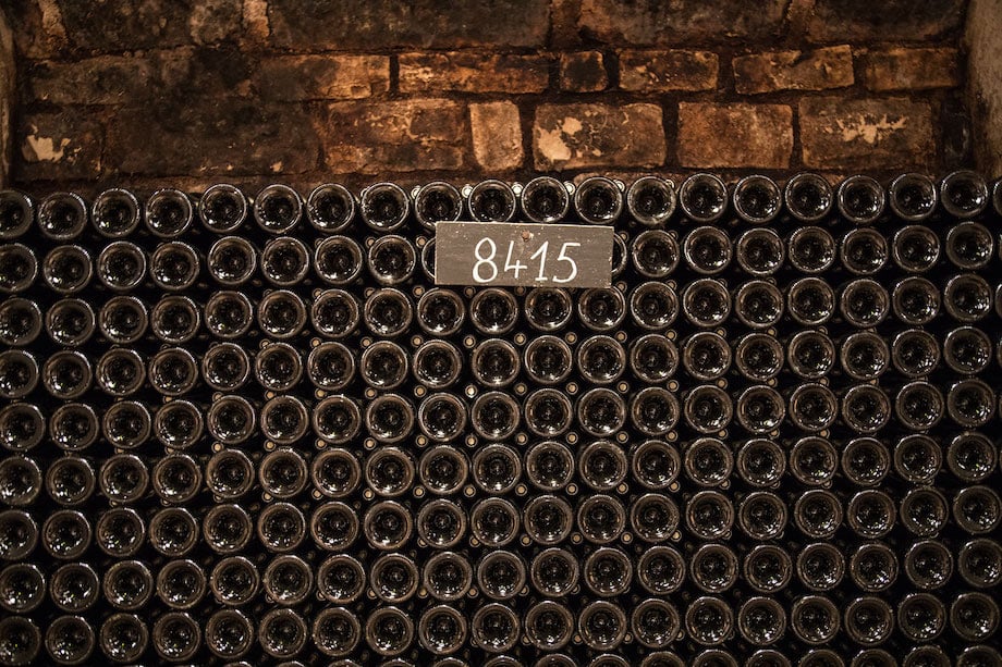 Image of stacked wine bottles in cellar, by Los Angeles product photographer Rocco Ceselin.