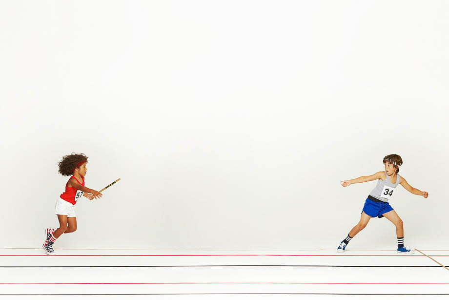 Conceptual photo of two kids in a relay race, with one about to pass the baton, taken by London-based sports photographer Rodolphe Opitch. 
