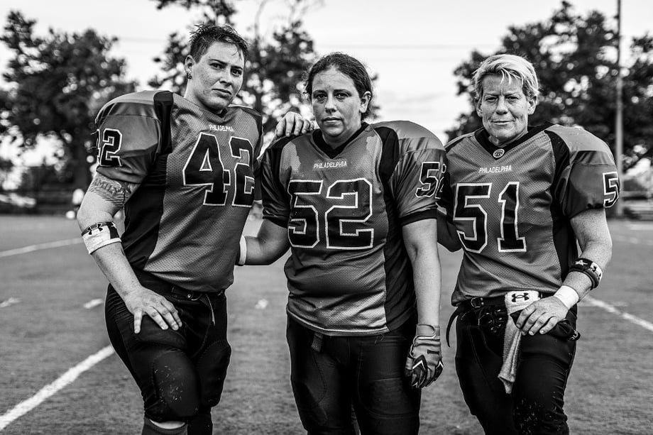Photo by Steve Boyle of three women posing in uniform after a football game.