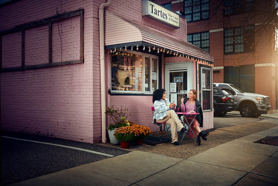 Photo of two women seated outside a cafe taken by Philadelphia-based lifestyle photographer Stevie Chris. 
