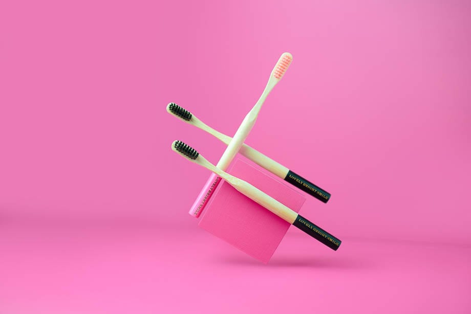 Photo of Lovely Bright Smile toothbrushes against a pink backdrop taken by Miami-based product photographer team The Daley Media. 