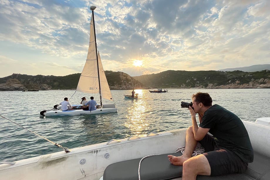 BTS of Tim Gerard Barker on a boat capturing photos for Aman Resorts Vietnam.