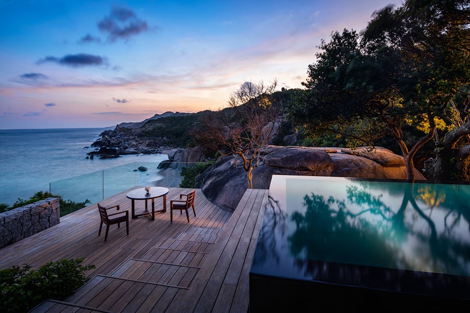 Outdoor photo of Infinity pool and table and chairs overlooking the ocean at Aman Resorts Vietnam.