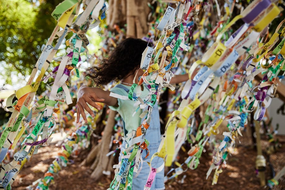 Photo of a tree with paper art decorations and a little girl in the midst of it taken by Tom Kubik. 
