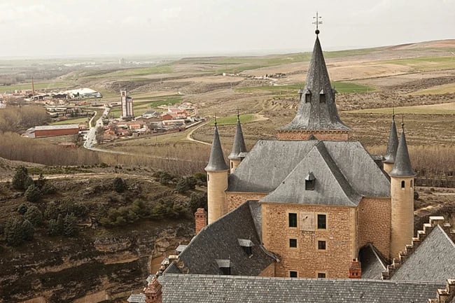 Aerial photography of architecture in Spain; a castle-like building surrounded by grass 