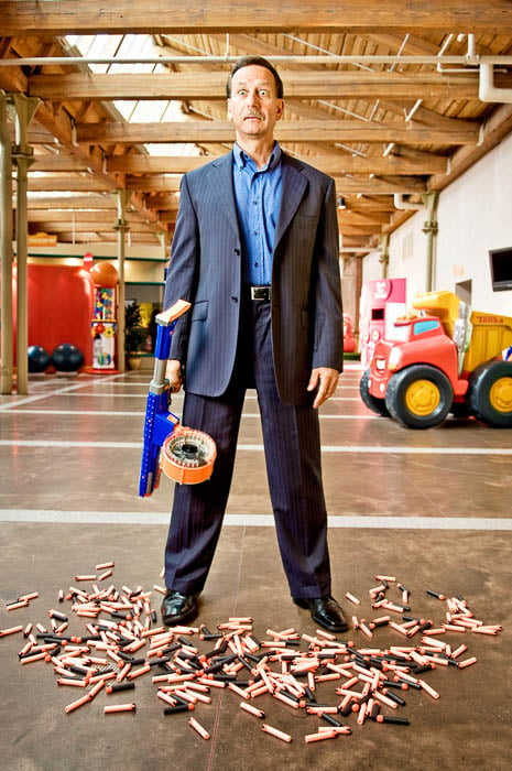Photo of John Frascotti of Hasbro with a toy pellet gun taken by Boston-based corporate photographer Webb Chappell. 