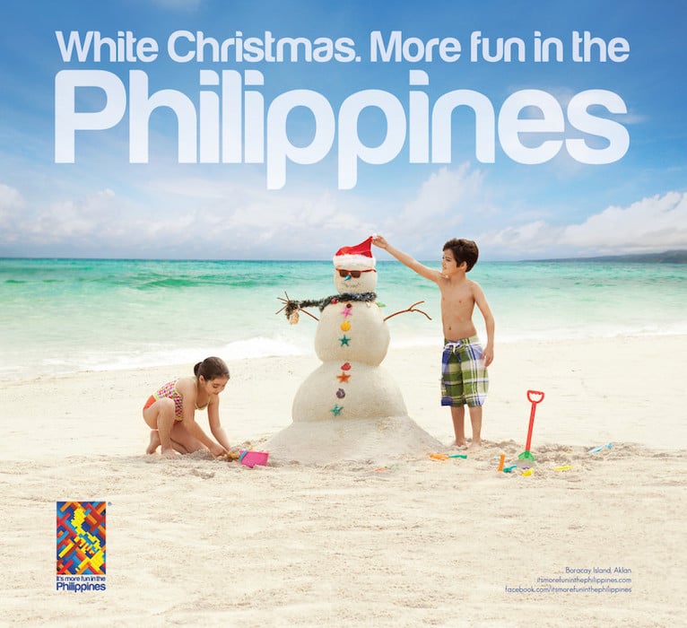 Two children making a snowman (or sandman, rather) on a beach with white text above reading "White Christmas. More fun in the Philippines"