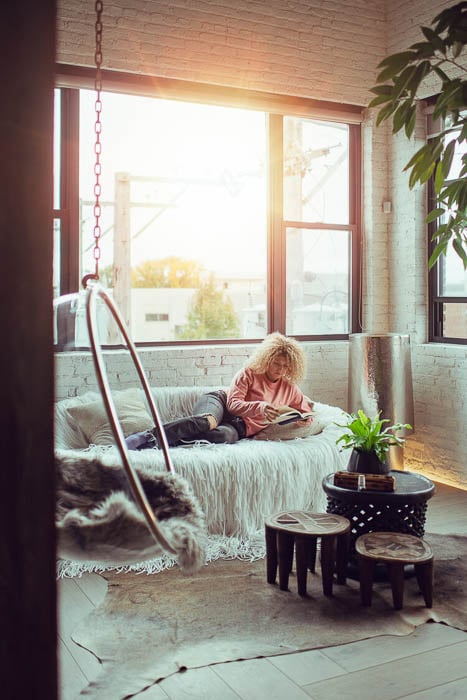 Photo of a woman lounging on a sofa and reading a book taken by Chicago-based lifestyle photographer Zoe Rain. 