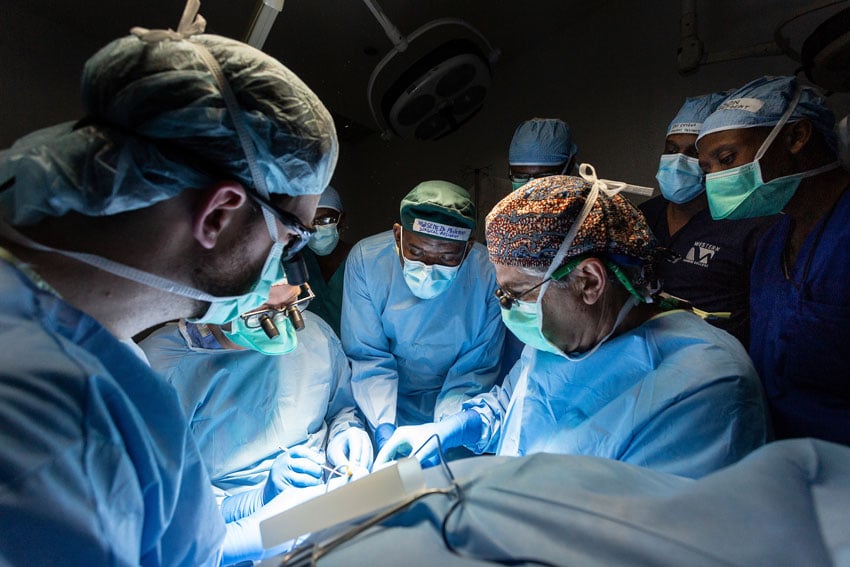 Four doctors perform surgery while others look on in this photo by Zute Lightfoot for Operation Smile 
