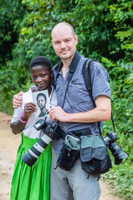 Zute Lightfoot poses with Faustina, who is holding a photo of what she looked like before her surgery from Operation Smile
