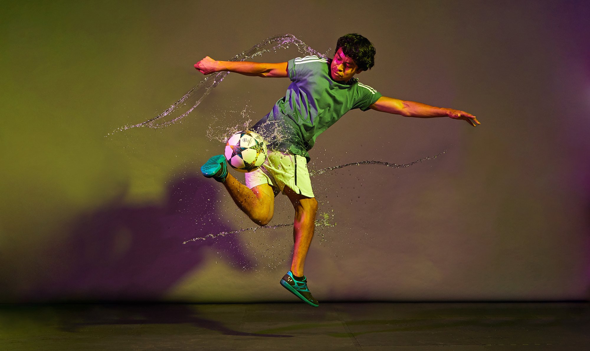 Male soccer player being splashed with artistic water streams