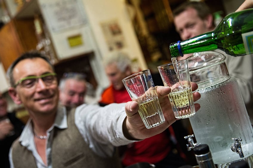 A man drinking absinthe at Distillerie Armand Guy on the French-Swiss border shot by photographer Lou Bopp.