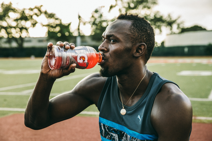 G L Askew II's portrait of Usain Bolt for Gatorade. Usain drinks a red gatorade.