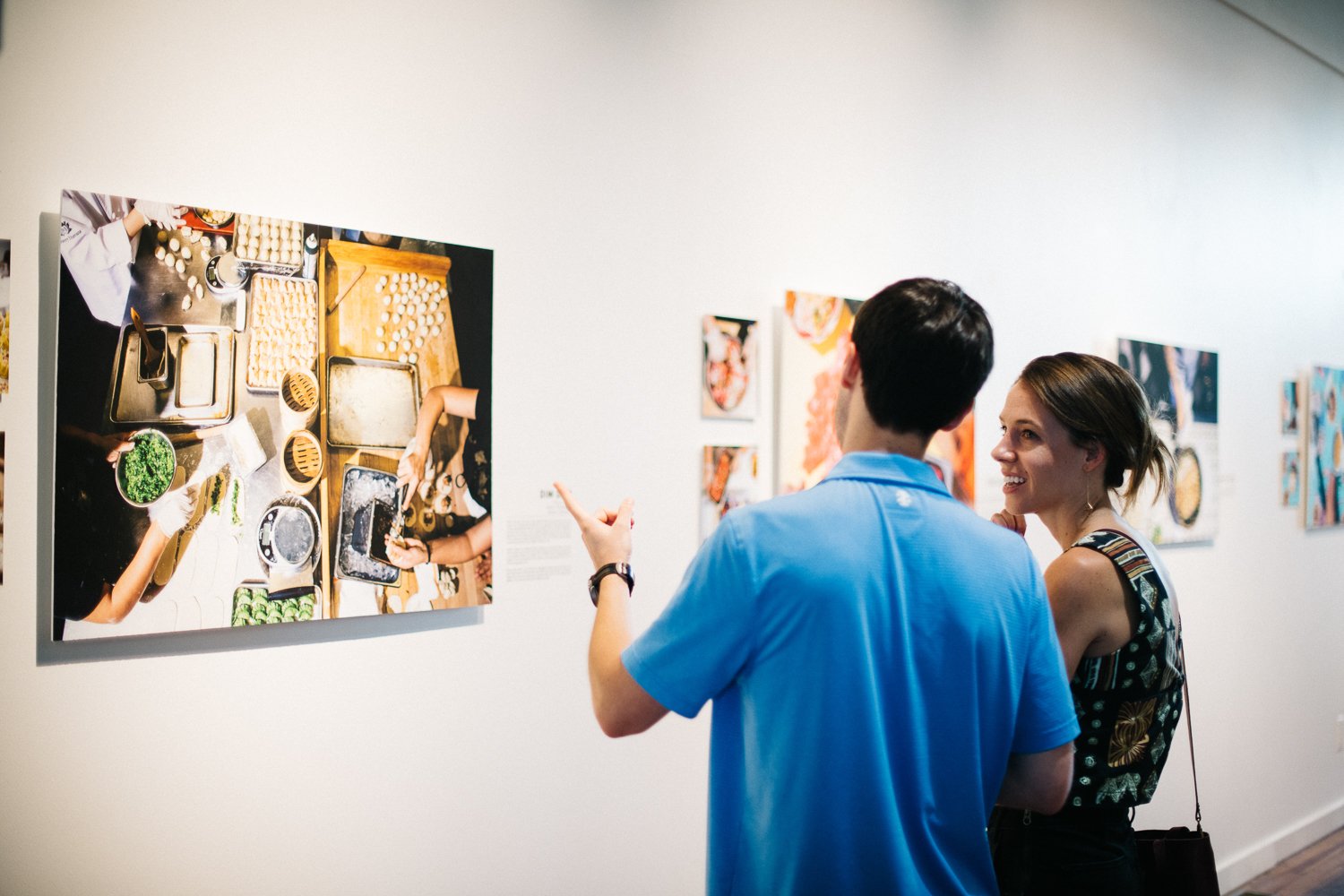Lauren V. Allen grabs a candid shot of a couple looking at CRAVINGS the The Carrack gallery