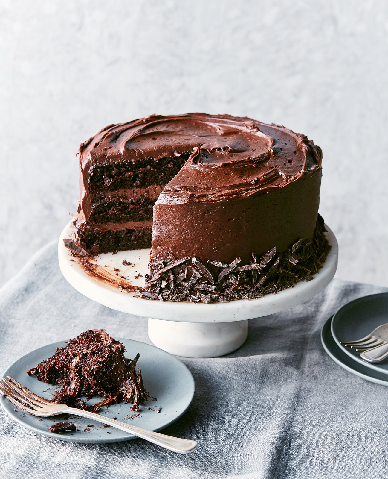 Colin Price's photo of Maria's triple layer chocolate cake with chocolate frosting on a stand with a slice cut from it