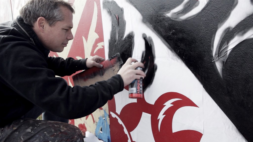 Shepard Fairey working on a mural shot by  Dallas-based portrait photographer Justin Clemons