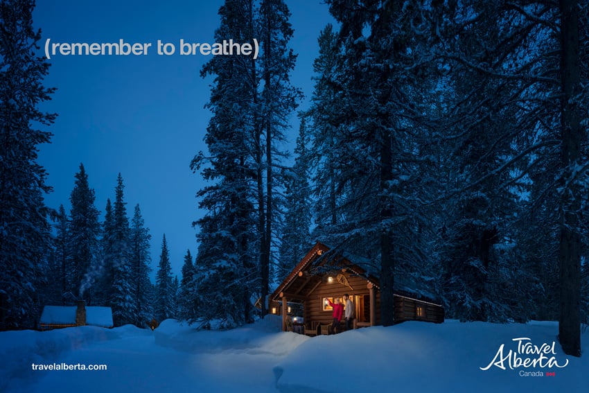 A photo revealing a charming wooden cabin nestled in a pristine winter wonderland. Photo by Gerard Yunker.
